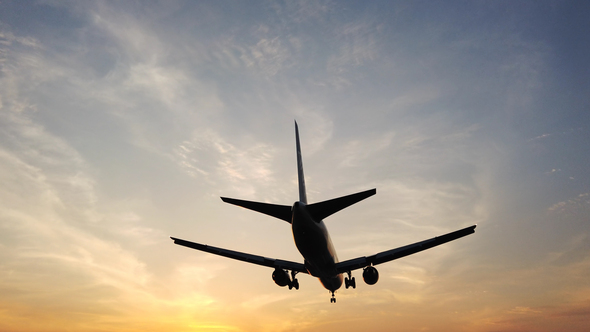 Airplane Landing In Airport At Sunset alt