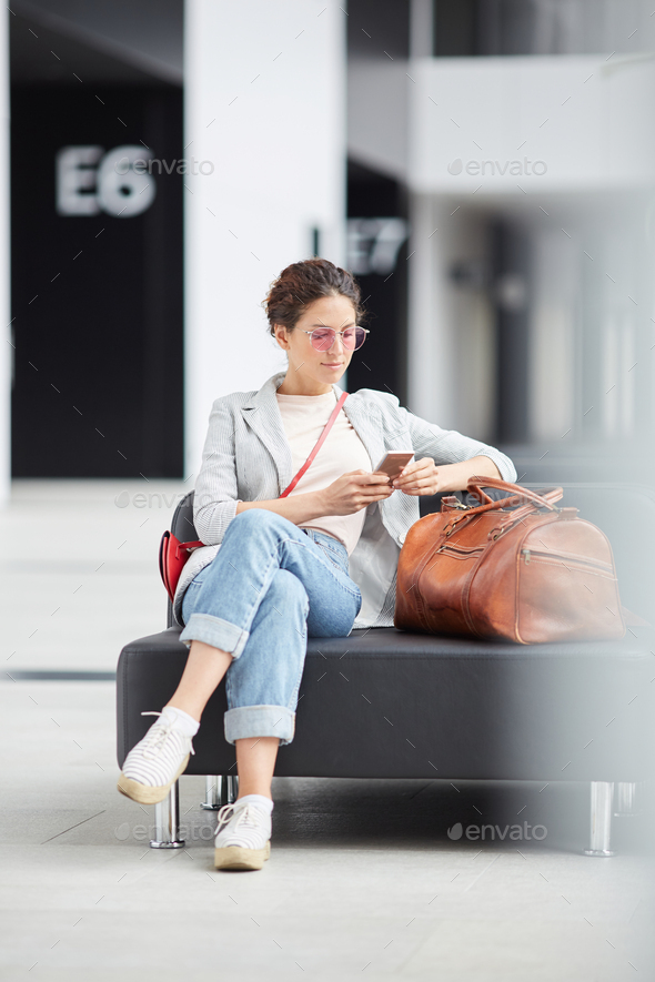 Hipster girl surfing net in airport waiting area