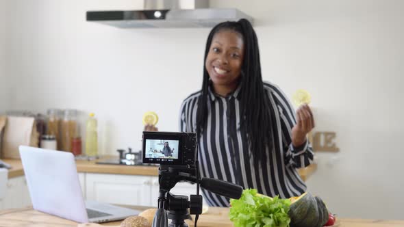 African American woman vlogger broadcasting live video streaming online teaching cooking in kitchen