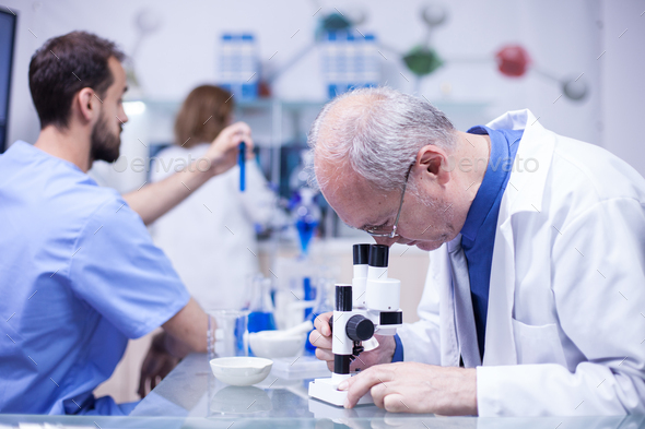 Senior technician making a discovery while working on microscope - Stock Photo - Images