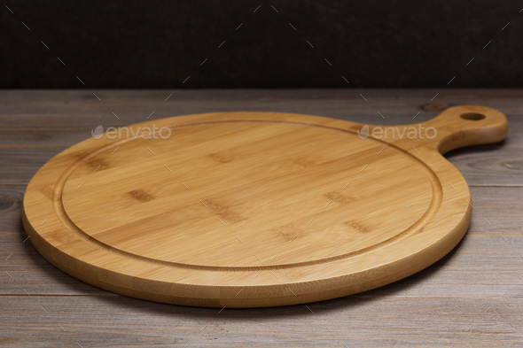 pizza cutting board at rustic wooden table Stock Photo by seregam