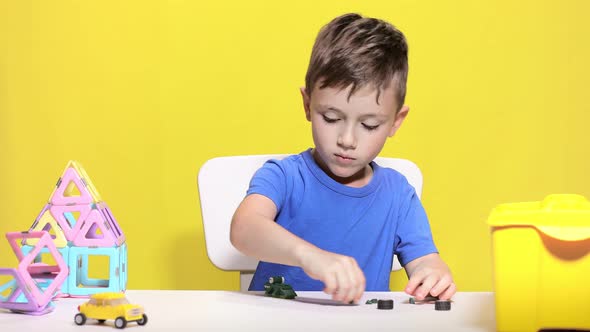 Clever little boy makes crocodile with children's designer. alt
