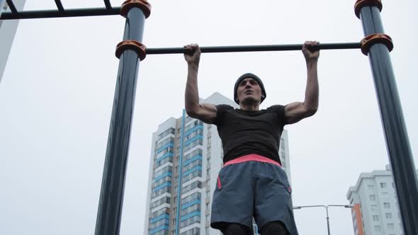 Muscular man training outdoors on sports field