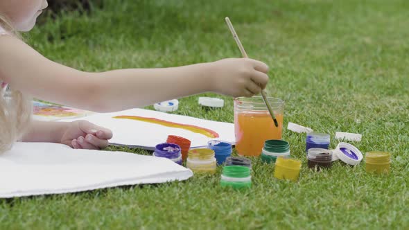 Blonde girl paints with paints