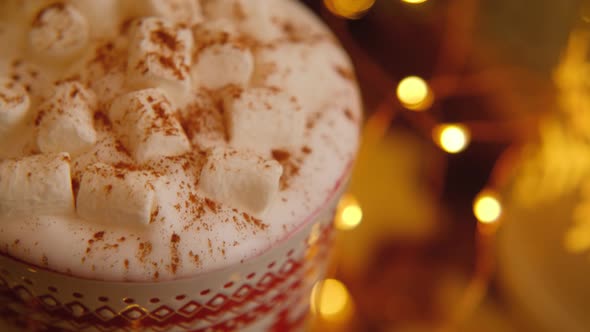 Close-up of a beautiful Christmas mug standing near a Christmas tree