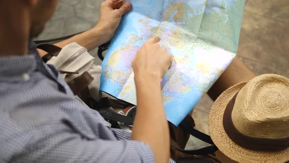 Male Hipster Traveler Reading Map While Sightseeing In City alt