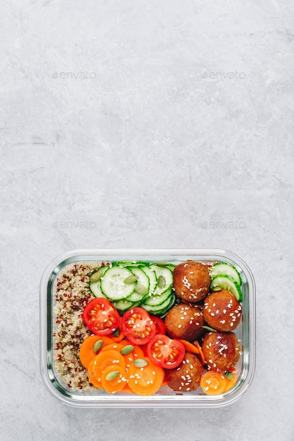 Meal prep lunch box containers with quinoa, meatballs cucumbers