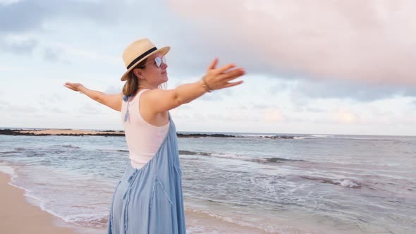 Smiling Woman on Ocean Beach at Cinematic Sunrise Pink Clouds Above Calm Ocean alt