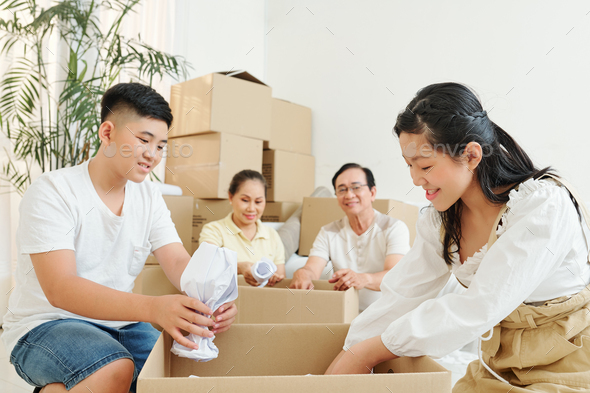 Teens wrapping fragile things - Stock Photo - Images