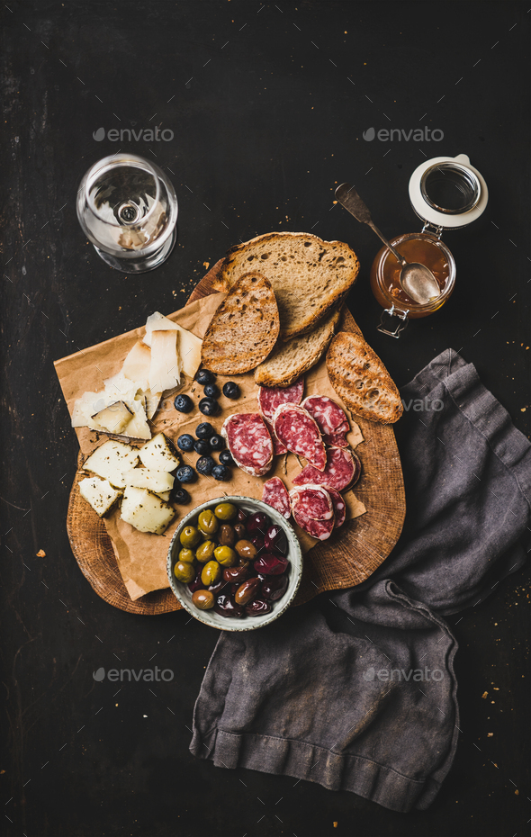 White wine and snack set over black background, top view Stock Photo by