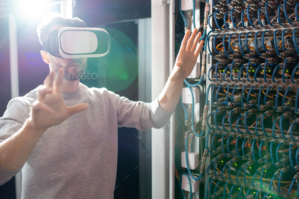 Engineer in VR goggles working in database center - Stock Photo - Images