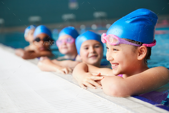 Group Of Children In Water At Edge Of Pool Waiting For Swimming Lesson
