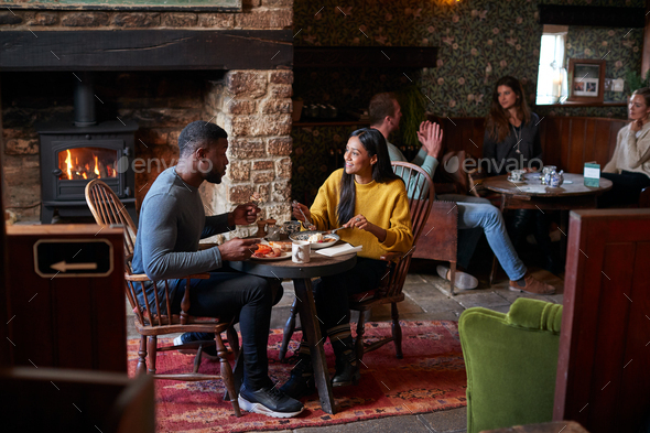 Couple At Table In Traditional English Pub Eating Breakfast