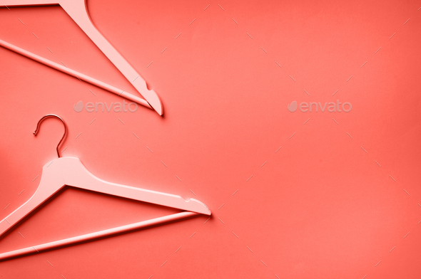 Top view of white clothes hangers on trendy coral background with copy  space. Flat lay. Minimalism Stock Photo by jchizhe