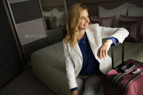 Portrait of attractive businesswoman sitting on bed - Stock Photo - Images
