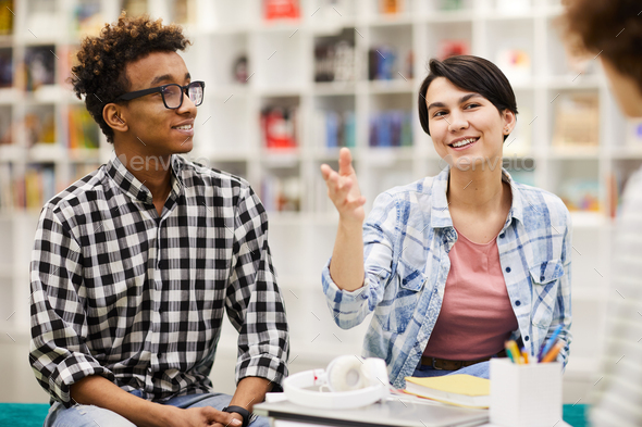 Creative students discussing ideas in library - Stock Photo - Images