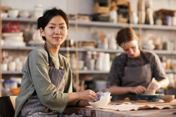 Polishing ceramic bowl in workshop - Stock Photo - Images