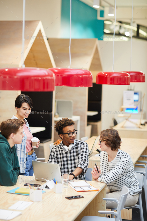 Multiethnic students discussing university project in cafe - Stock Photo - Images
