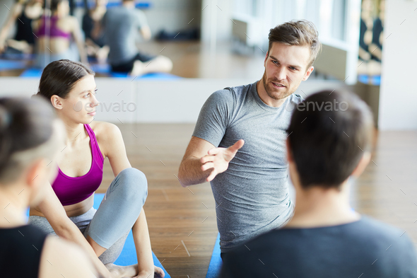 Sporty guy sharing ideas at yoga class - Stock Photo - Images