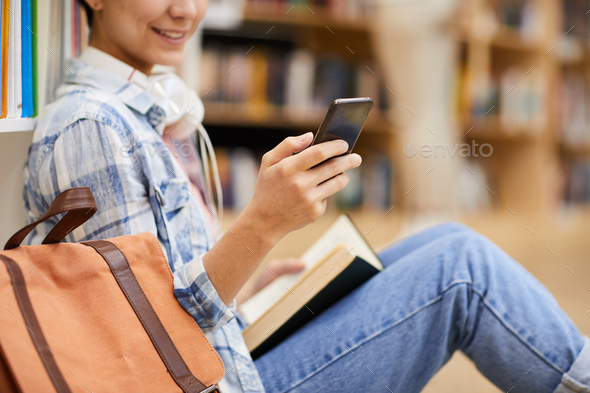 Texting sms in library - Stock Photo - Images