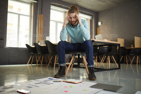 Puzzled Businessman Looking at Documents - Stock Photo - Images