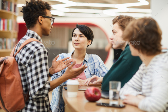 Multiethnic high school friends discussing project - Stock Photo - Images