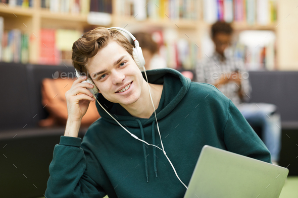 Handsome young student in library area - Stock Photo - Images
