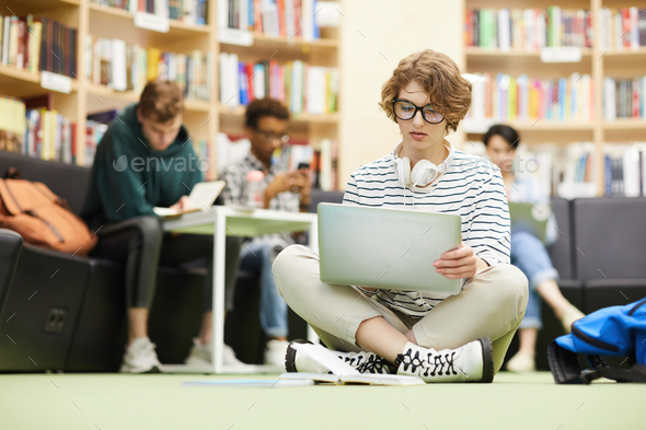 Pensive student girl analyzing online resources - Stock Photo - Images