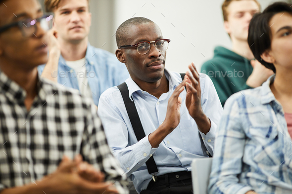 African conference participant applauding for speaker - Stock Photo - Images