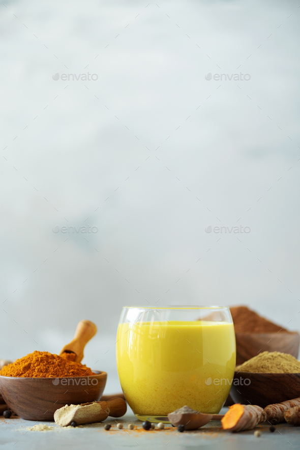 Ingredients for turmeric latte. Turmeric powder, curcuma root, cinnamon, ginger over grey background - Stock Photo - Images