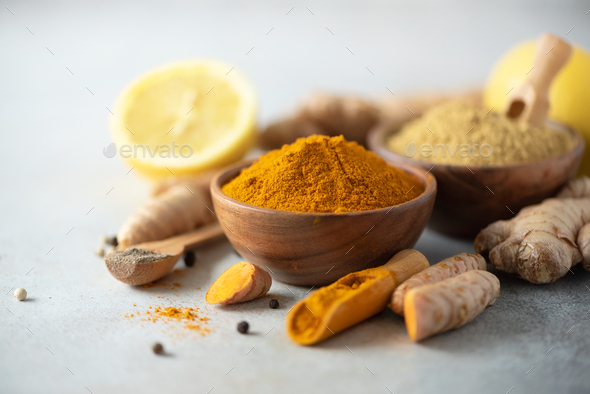 Ingredients for hot ayurvedic drink. Turmeric powder, curcuma root, cinnamon, ginger, lemon over - Stock Photo - Images