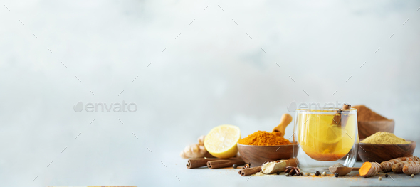 Ingredients for turmeric hot tea on grey background. Healthy ayurvedic drink with lemon, ginger - Stock Photo - Images
