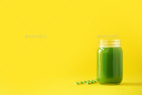 Bottle of green celery smoothie on yellow background. Banner with copy space. Fresh juice for detox - Stock Photo - Images