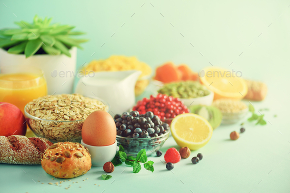 Delicious breakfast ingredients. Soft boiled egg, oat flakes, nuts, fruits, berries, milk, yogurt - Stock Photo - Images