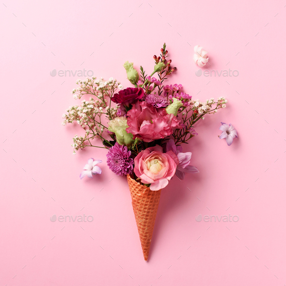 Summer minimal concept. Ice cream cone with pink flowers and leaves on punchy pastel background - Stock Photo - Images