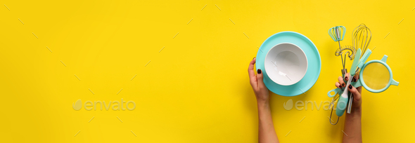 Baking flat lay. Female hands holding plate, bowl, kitchen tools, sieve, rolling pin, spatula and - Stock Photo - Images