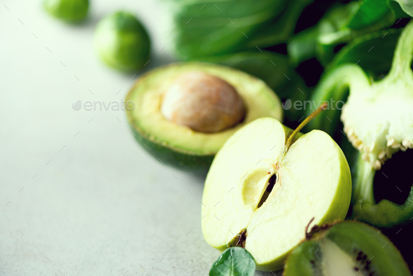 Organic green vegetables and fruits on grey background. Copy space. Green apple, lettuce, cucumber - Stock Photo - Images