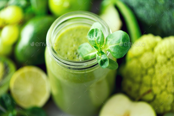 Glass jar mugs with green health smoothie, kale leaves, lime, apple, kiwi, grapes, banana, avocado - Stock Photo - Images