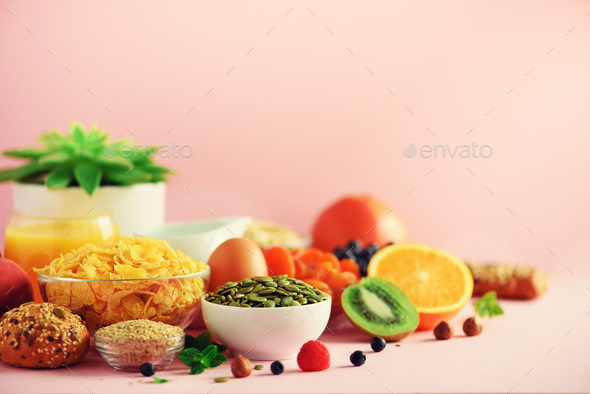 Breakfast served with soft boiled egg, oat flakes, nuts, fruits, berries, milk, yogurt, orange - Stock Photo - Images