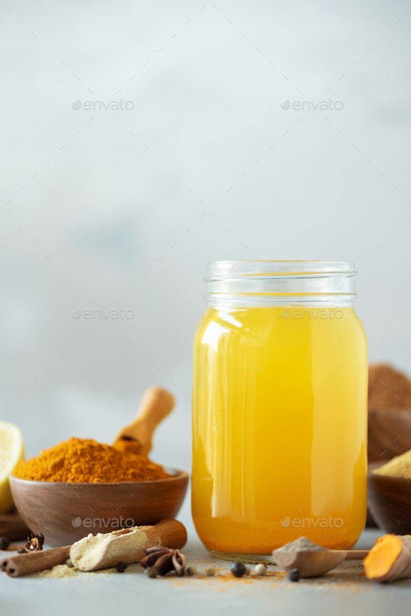 Ingredients for orange turmeric drink on grey concrete background. Lemon water with ginger, curcuma - Stock Photo - Images