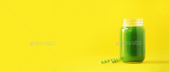 Bottle of green celery smoothie on yellow background. Banner with copy space. Fresh juice for detox - Stock Photo - Images
