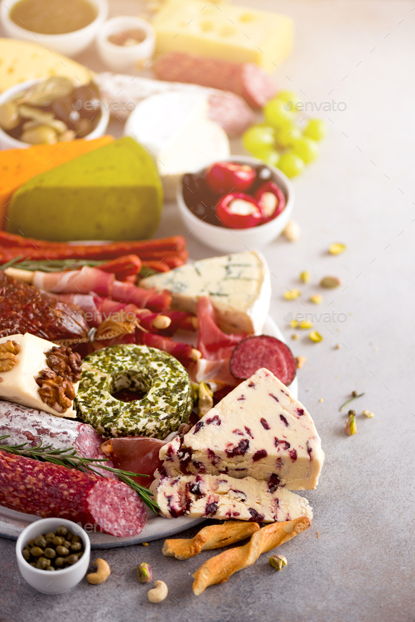 Cutting board with salami, cold smoked meat, prosciutto, ham, cheeses on grey background. Cheese and - Stock Photo - Images