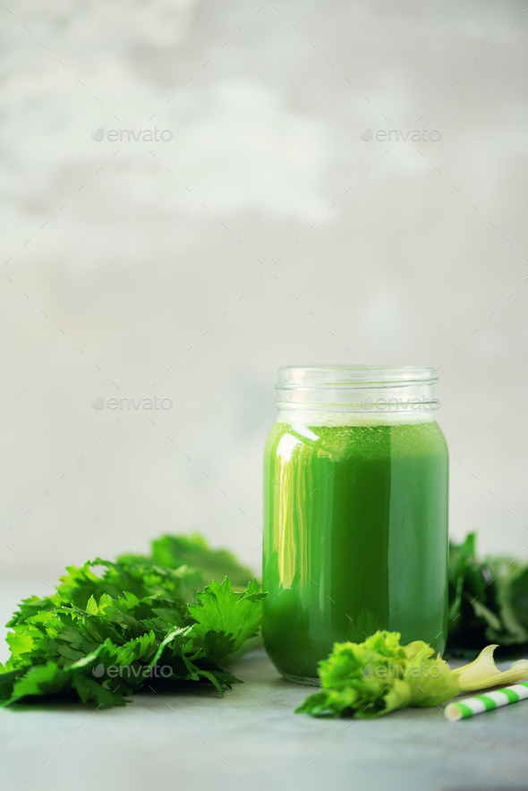 Bottle of green celery smoothie on grey concrete background. Banner with copy space. Square crop - Stock Photo - Images
