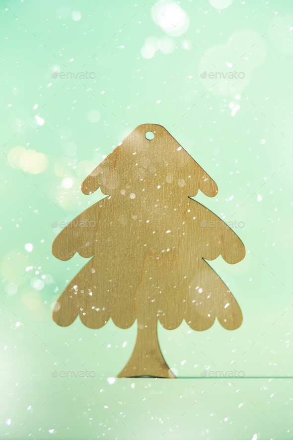 Greeting card in minimal style. Wooden Christmas tree on blue background with copy space, lights - Stock Photo - Images