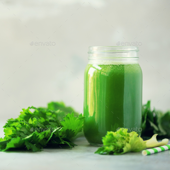 Bottle of green celery smoothie on grey concrete background with copy space. Square crop. Fresh - Stock Photo - Images