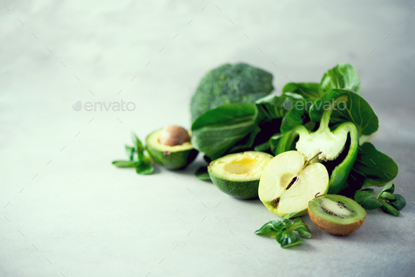 Organic green vegetables and fruits on grey background. Copy space. Green apple, lettuce, cucumber - Stock Photo - Images