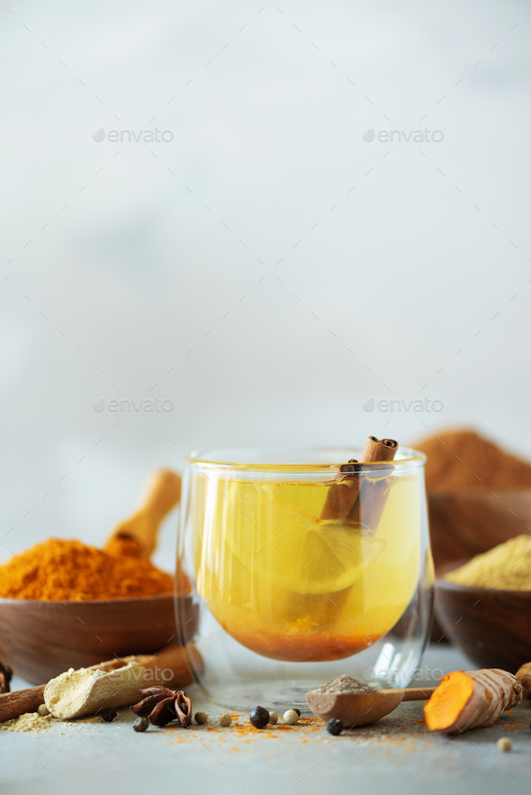 Ingredients for turmeric hot tea on grey background. Healthy ayurvedic drink with lemon, ginger - Stock Photo - Images