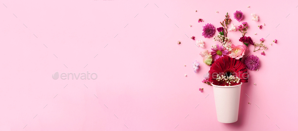 Creative layout made of white paper cup with pink flowers. Flat lay, top view. Banner with copy - Stock Photo - Images