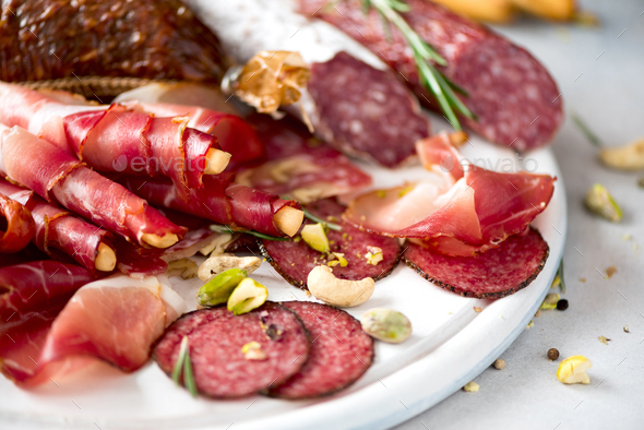 Traditional italian antipasto. Cold smoked meat plate. Cutting board with salami, prosciutto, ham - Stock Photo - Images