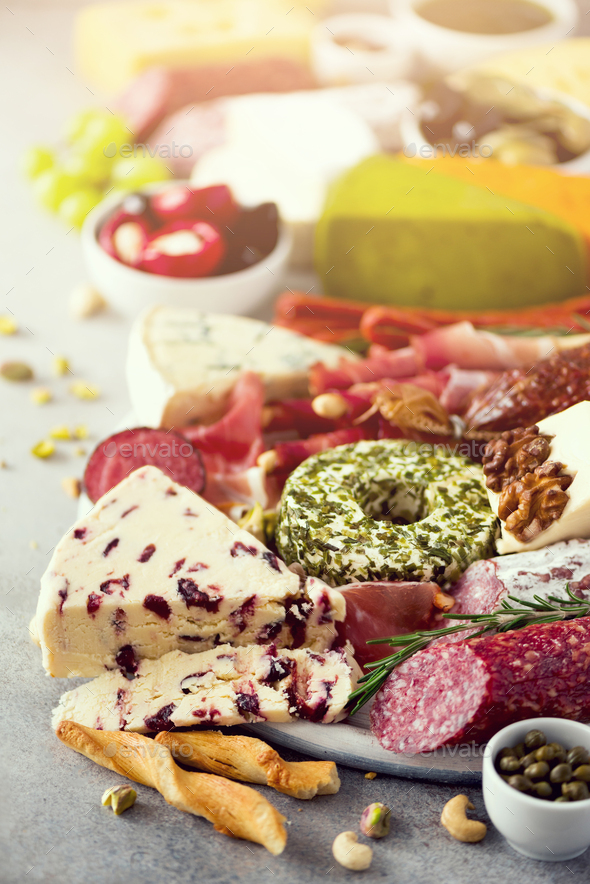 Cutting board with salami, cold smoked meat, prosciutto, ham, cheeses on grey background. Cheese and - Stock Photo - Images